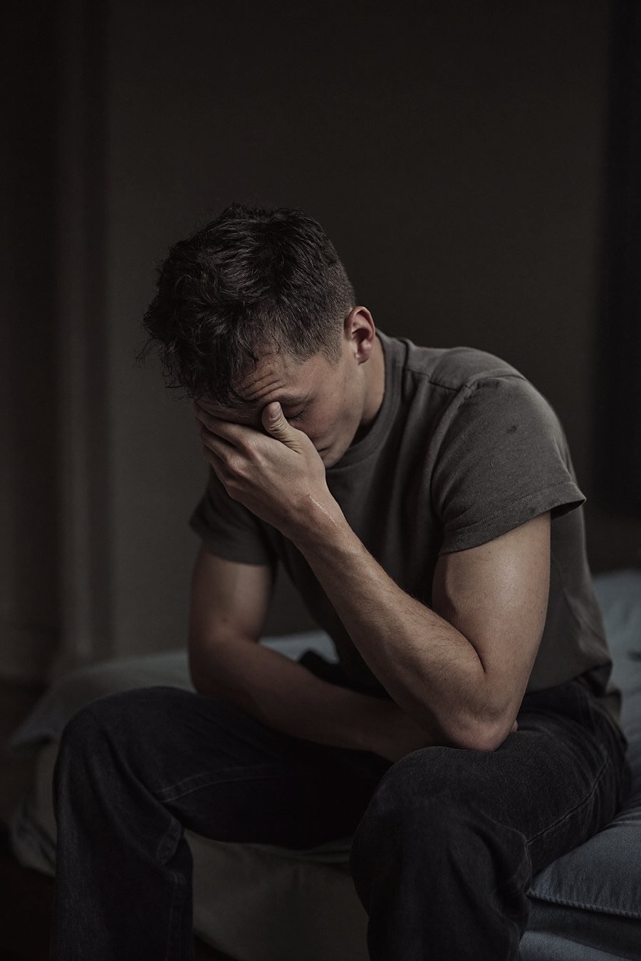 A man sitting alone, head in hands